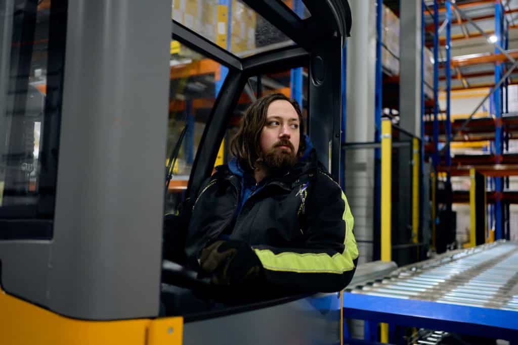 Medarbeider ved fabrikken i Drammen, i truck på lageret.